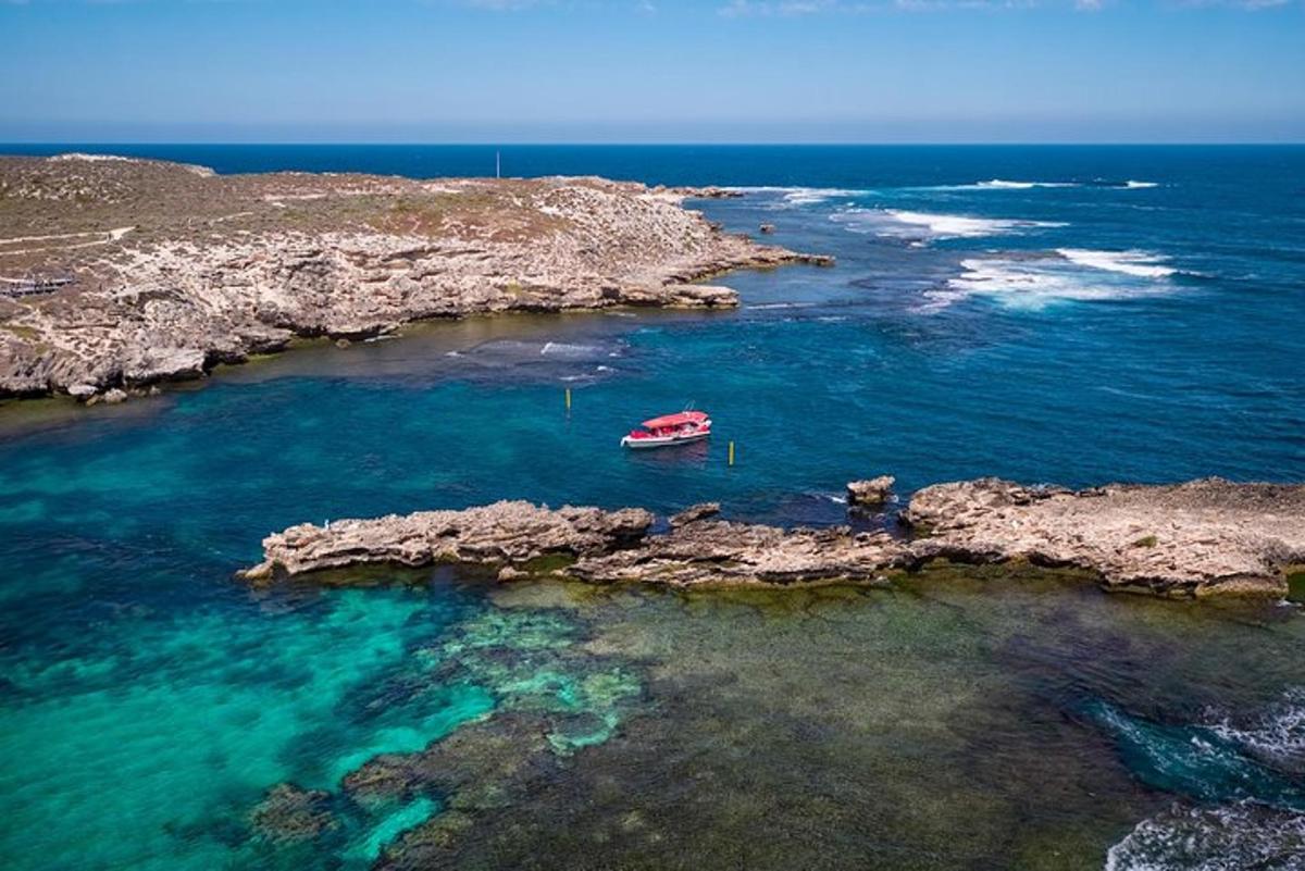 sebuah perahu di air di sebelah pantai berbatu