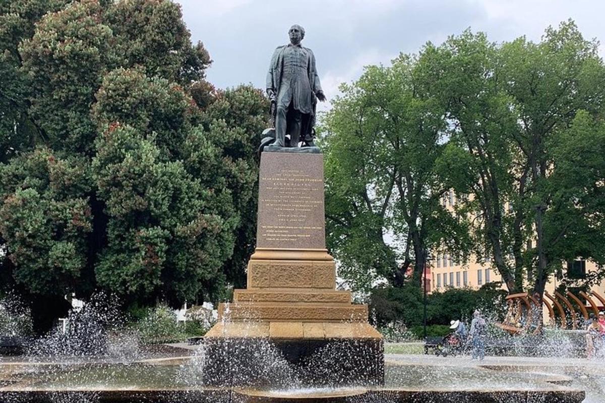 una estatua de un hombre de pie encima de una fuente