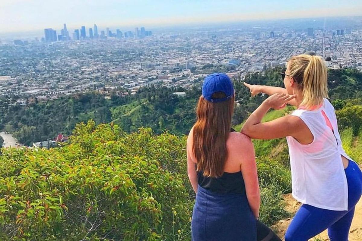 due donne in piedi sulla cima di una collina che guardano una città