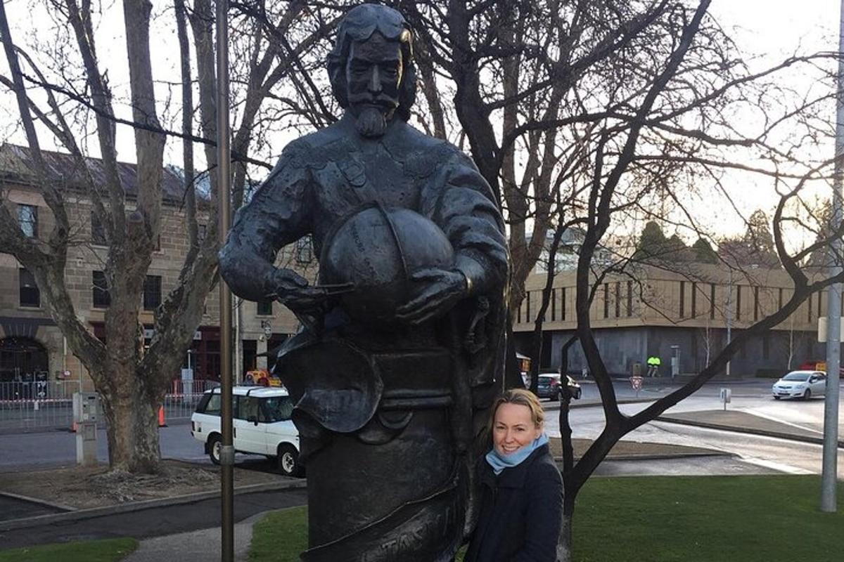 Una niña parada frente a una estatua