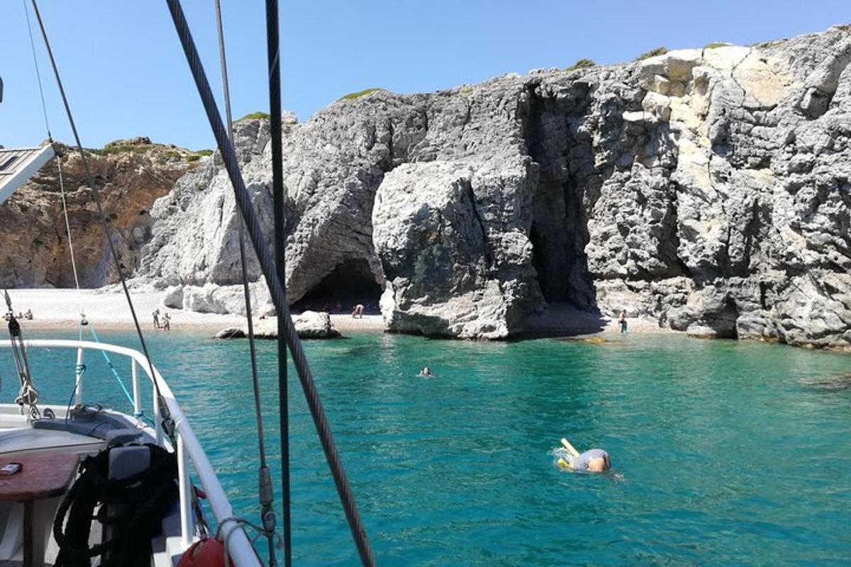 una persona che nuota nell'acqua vicino a una spiaggia