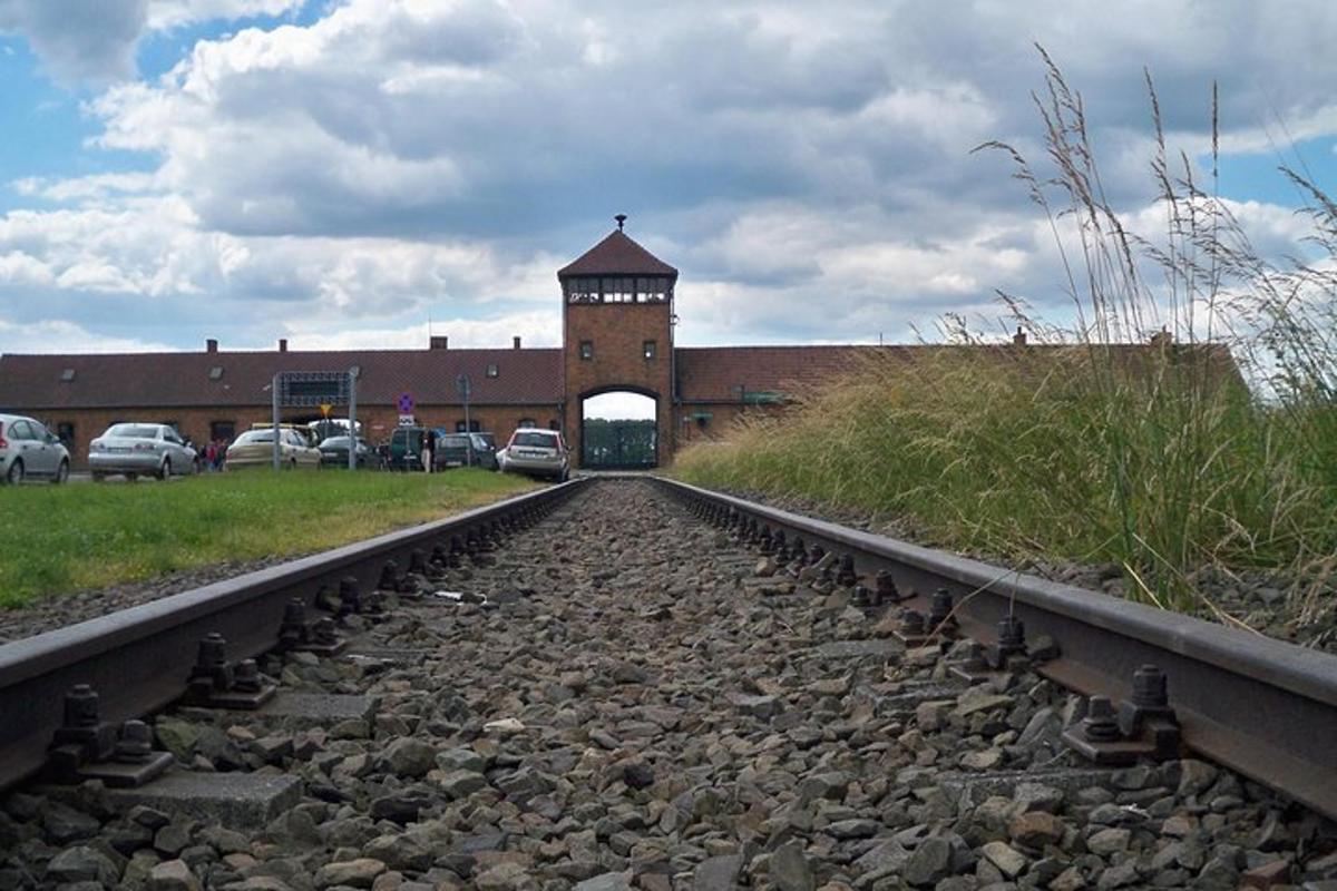 una via de tren davant d'un edifici amb una torre de rellotge