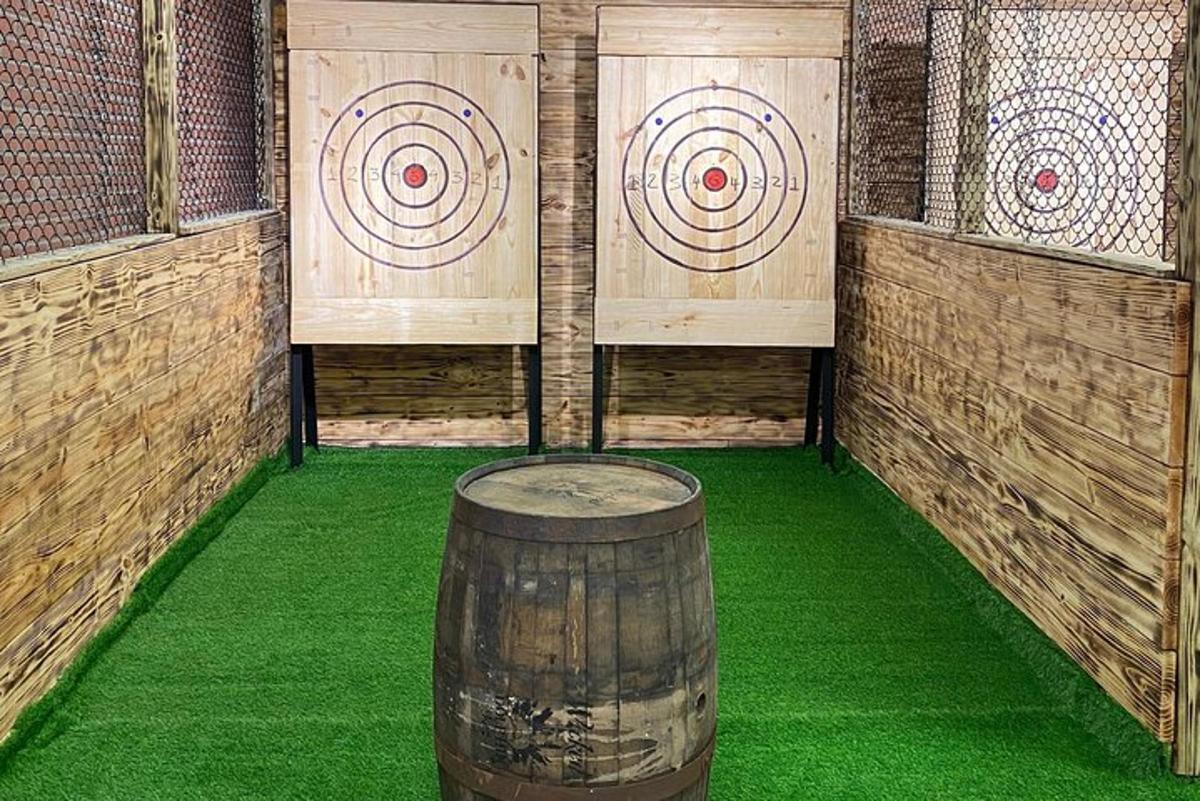 a room with a barrel and arrows on the wall