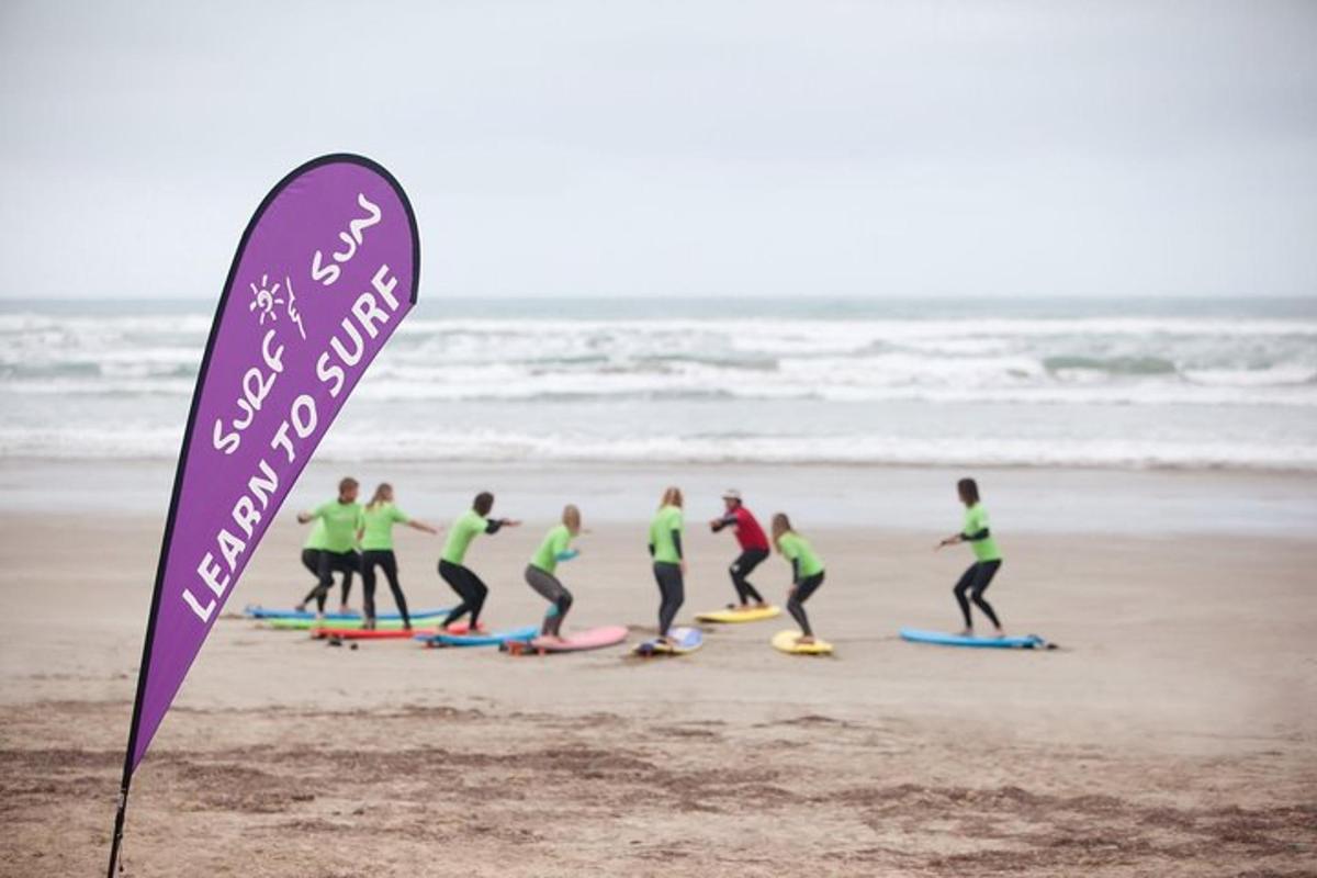 Un grupo de surfistas en la playa con un cartel.