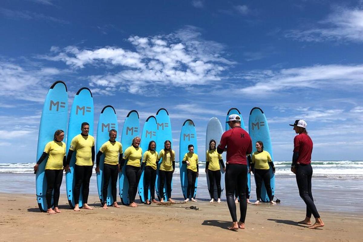 Un grupo de personas de pie en la playa con tablas de surf.