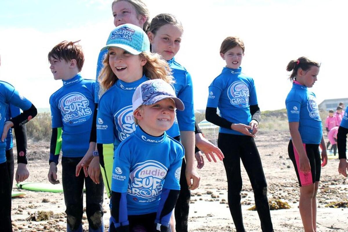 Un grupo de niños con camisas azules de pie en la playa.