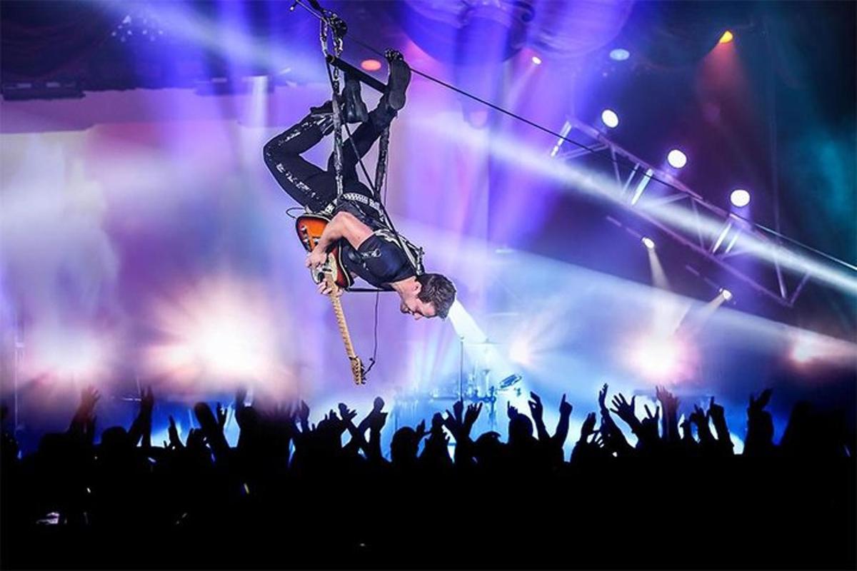 a man on a zip line in front of a crowd
