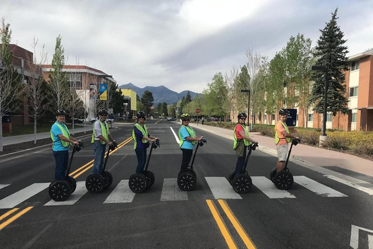 um grupo de pessoas andando de segway em uma rua