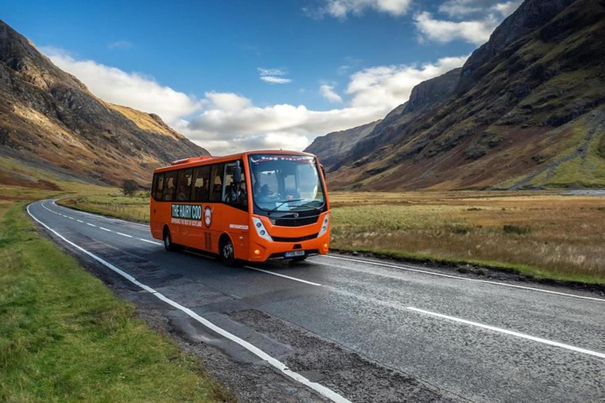 oranžový autobus jedoucí po silnici v horách