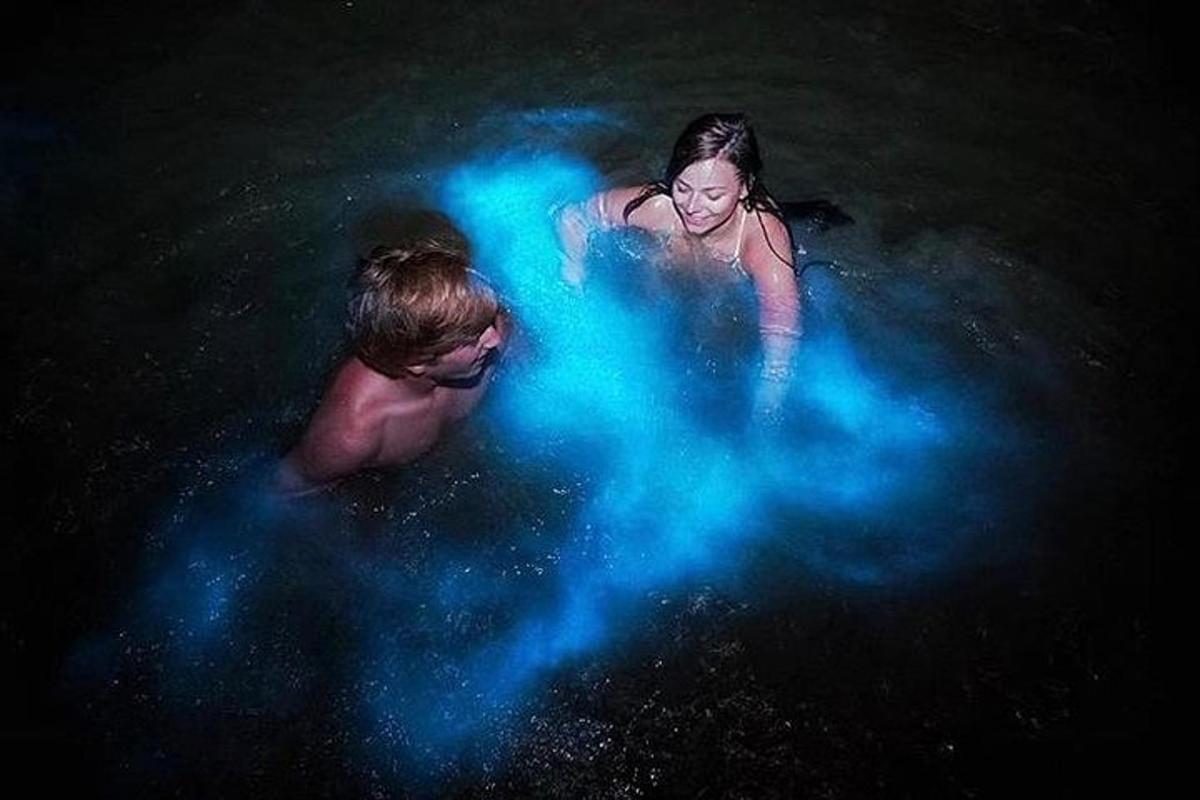 two people in the water with blue smoke