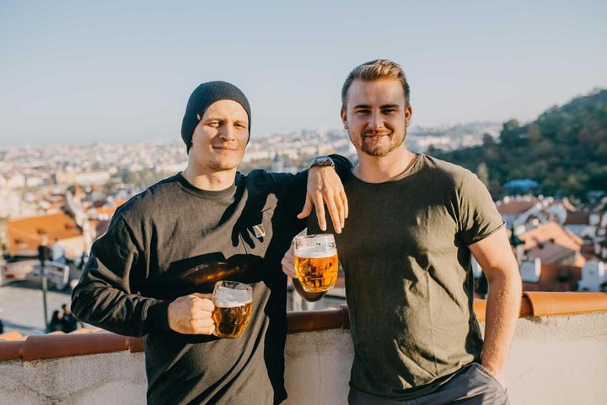 two men holding glasses of beer standing on a ledge