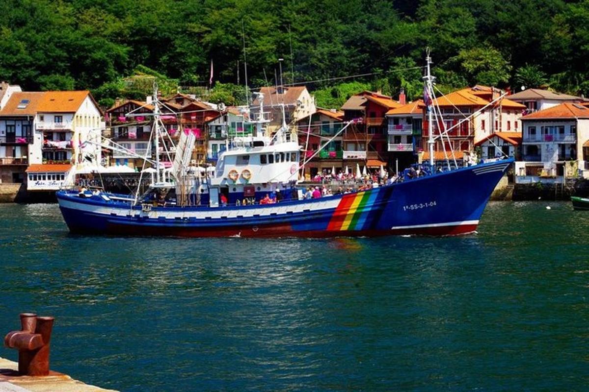 o barcă mare albastră cu un curcubeu pe ea în apă