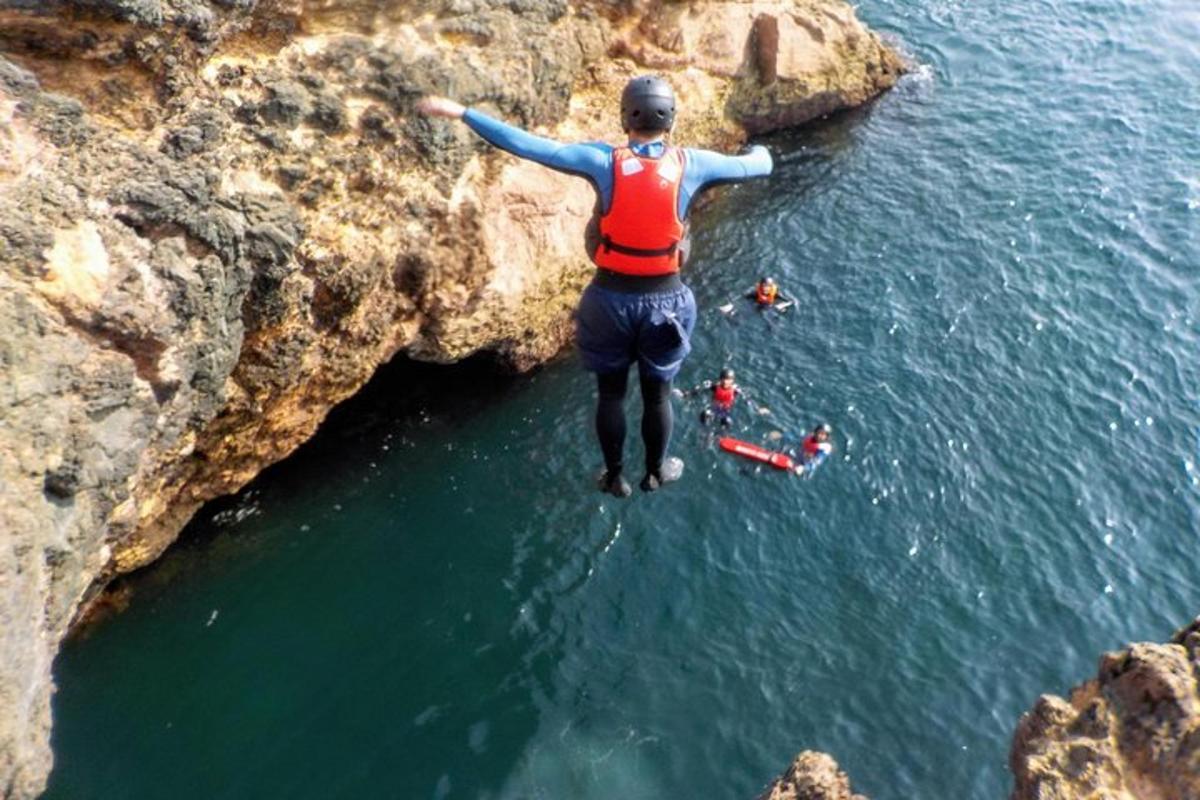 ein Mann, der von einer Klippe ins Wasser springt