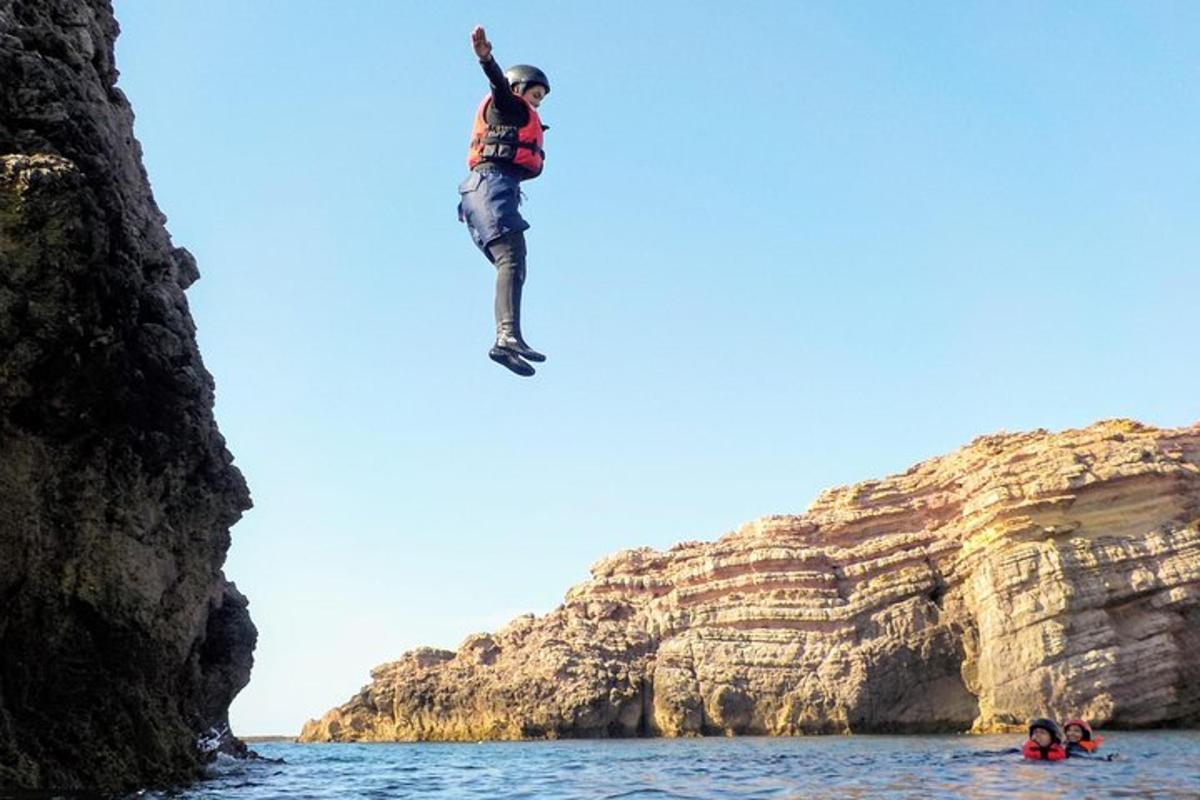 ένας άντρας πηδάει από έναν γκρεμό στο νερό