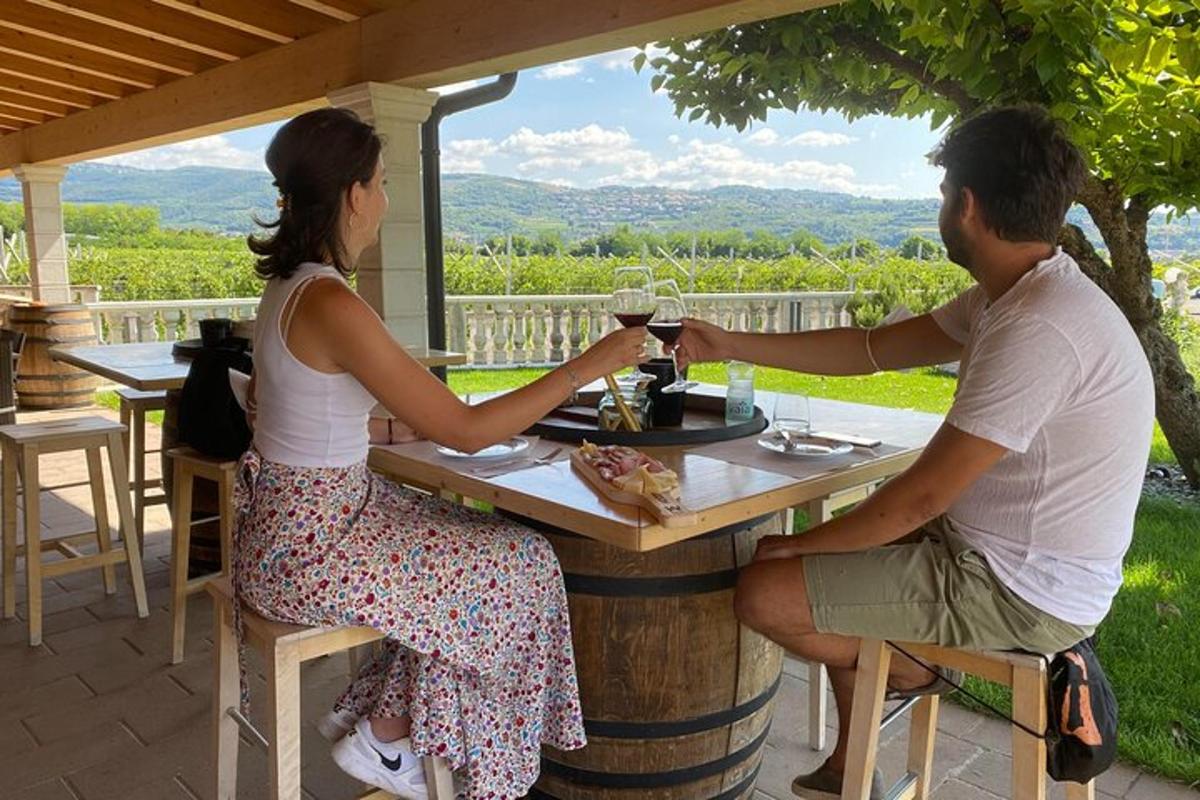 moški in ženska sedita za mizo s kozarcem vina