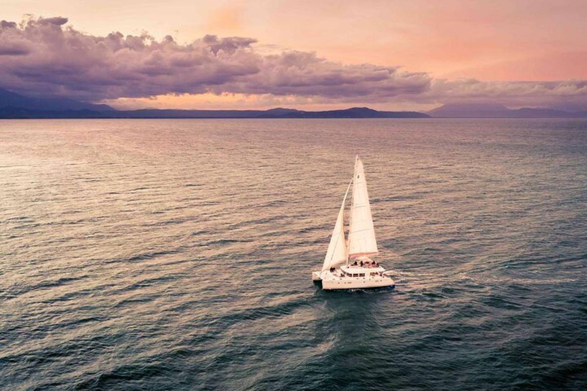 a small sailboat in the water at sunset