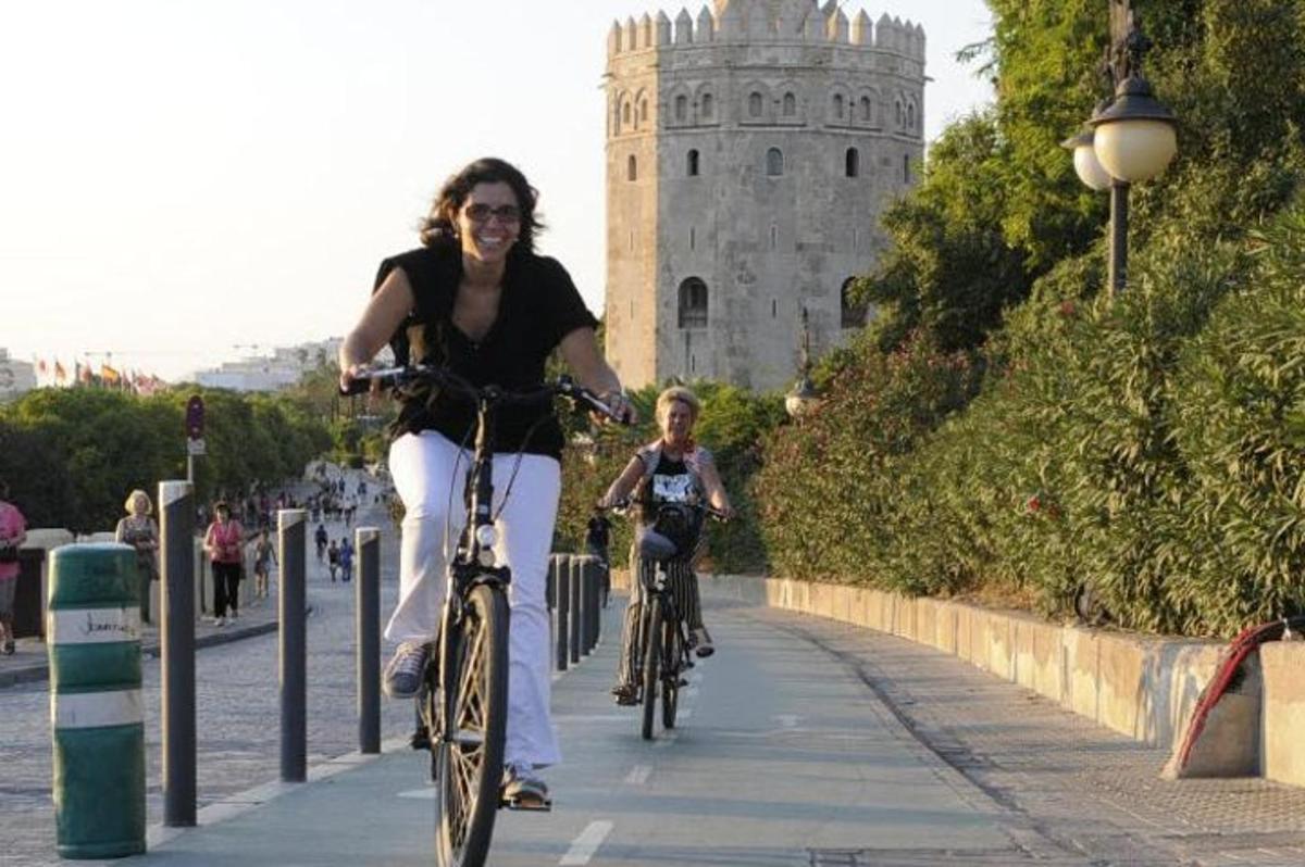 a woman and a child riding bikes down a sidewalk