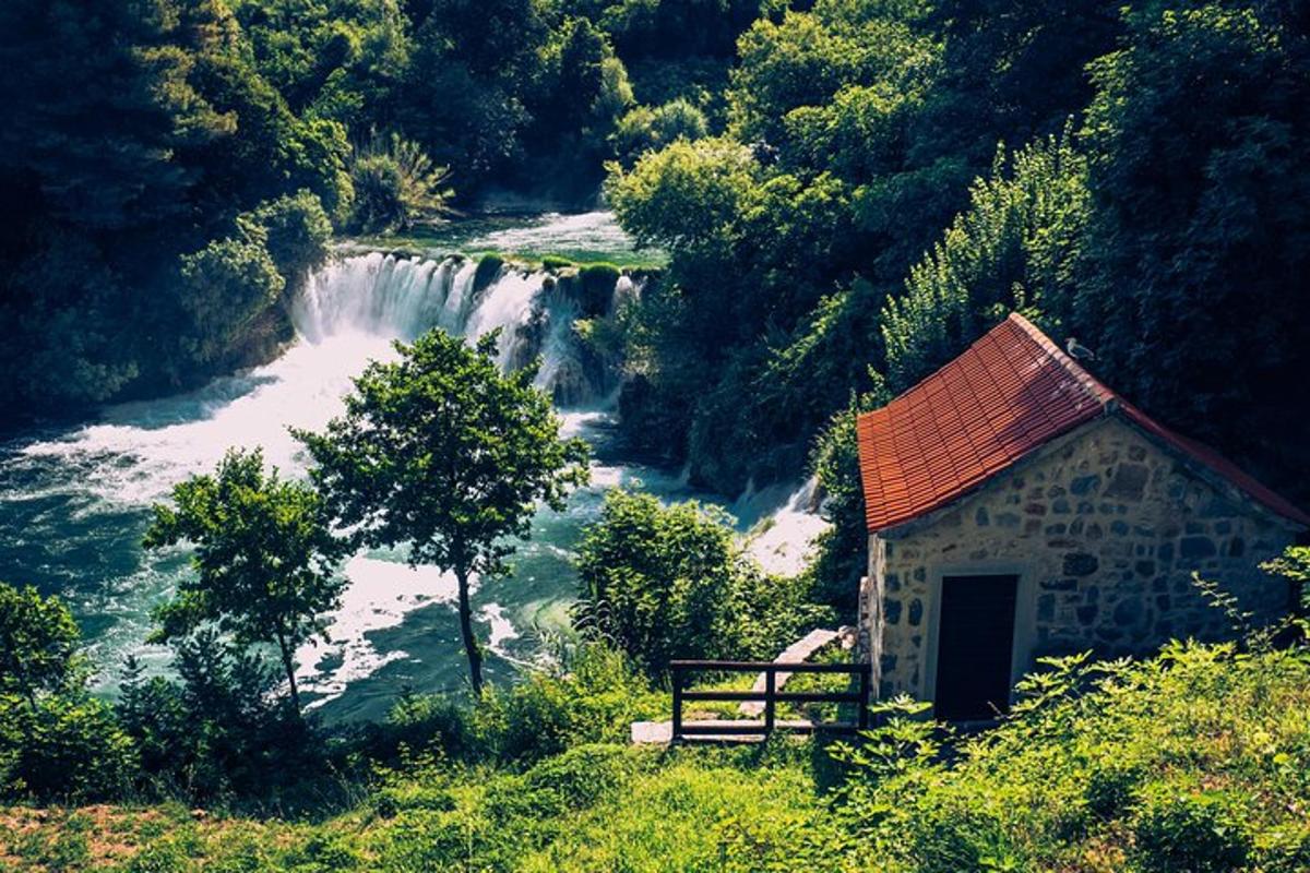 a small building next to a river with a waterfall