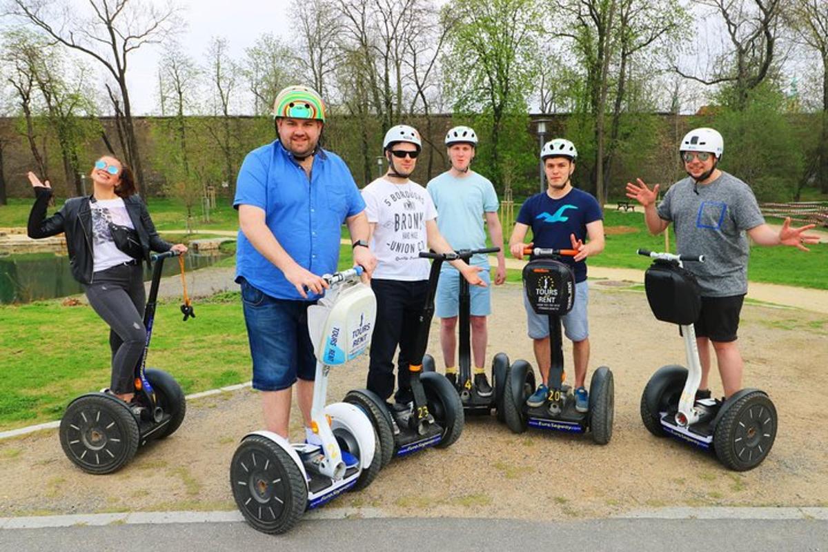 Skupina lidí jezdících na segwayích v parku