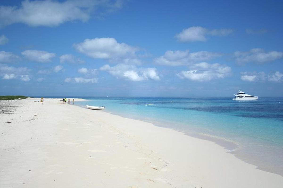 a white beach with a boat in the water