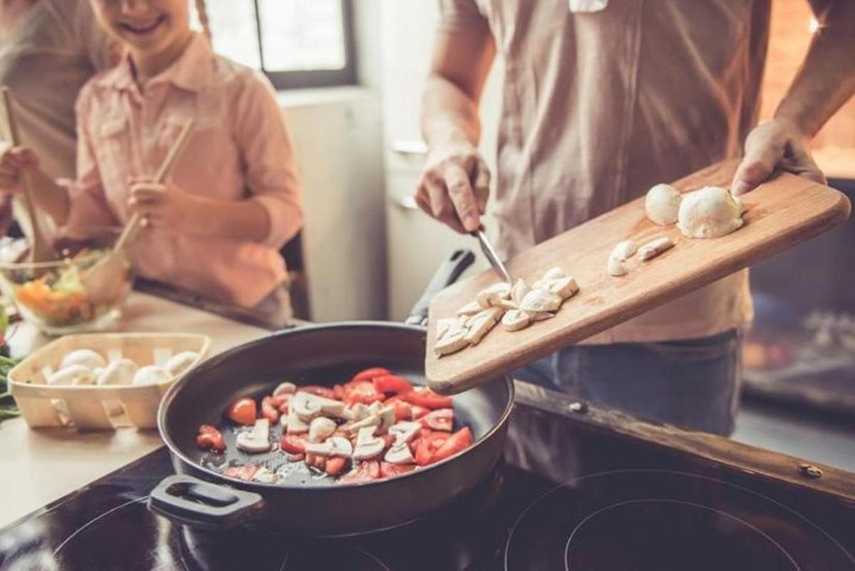 a man cooking food in a pan on a stove
