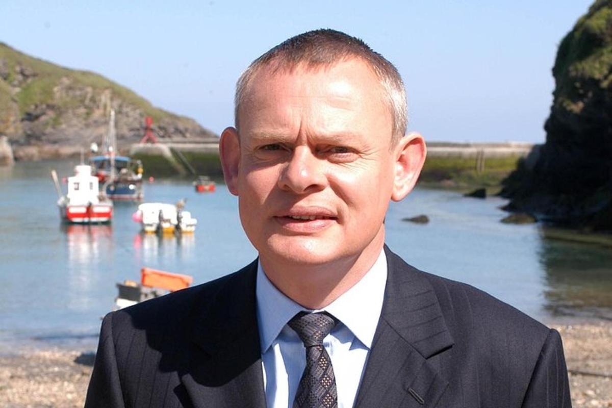 a man in a suit and tie with boats in the water