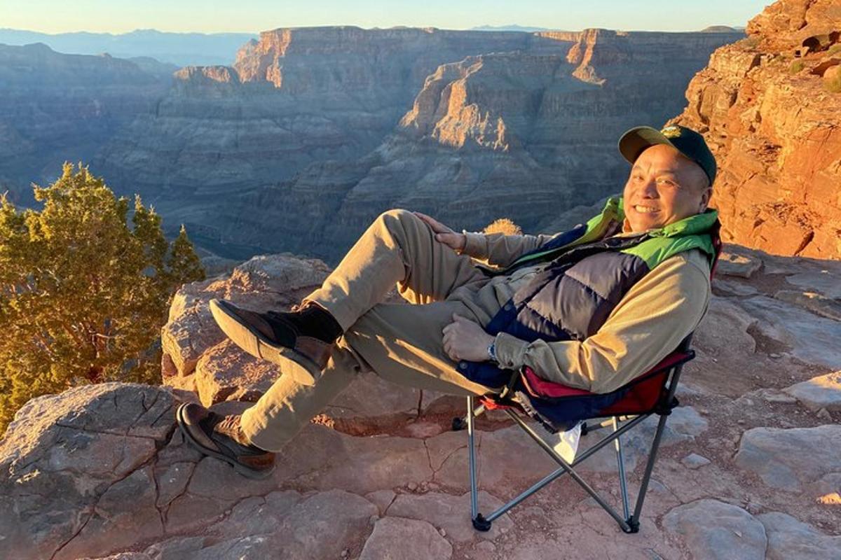a man sitting in a chair at the grand canyon