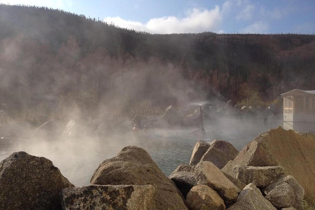 a group of rocks in a body of water with fog