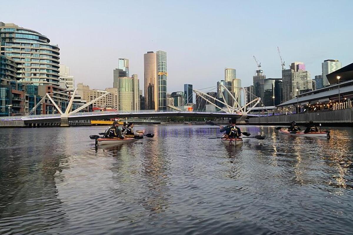 un grup de persones en canoes per un riu d'una ciutat