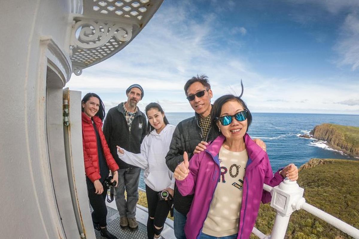 a group of people standing on a balcony with the ocean