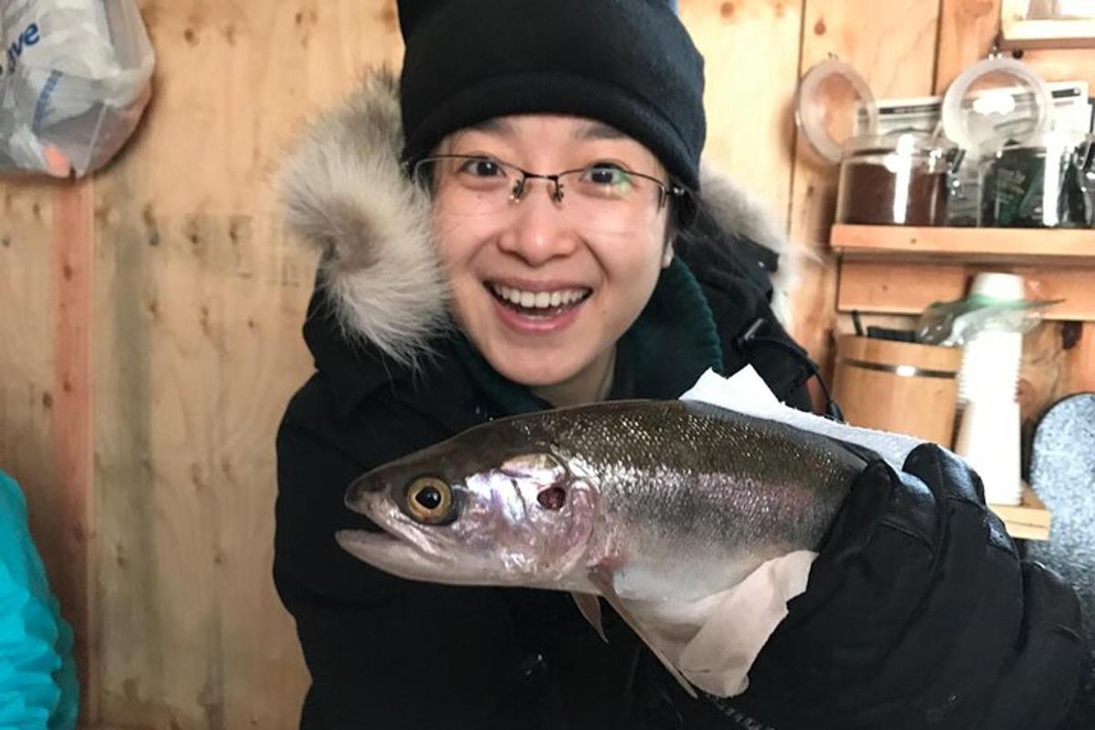 una mujer sosteniendo un pescado en su mano