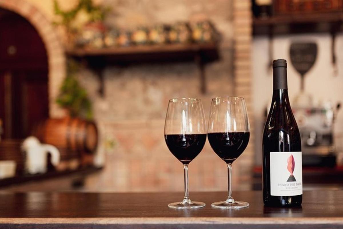 two glasses of red wine sitting on a counter