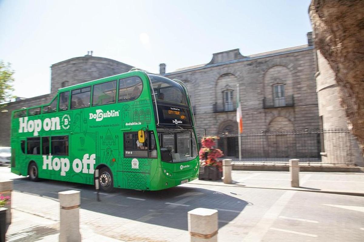 um ônibus verde de dois andares estacionado em frente a um prédio