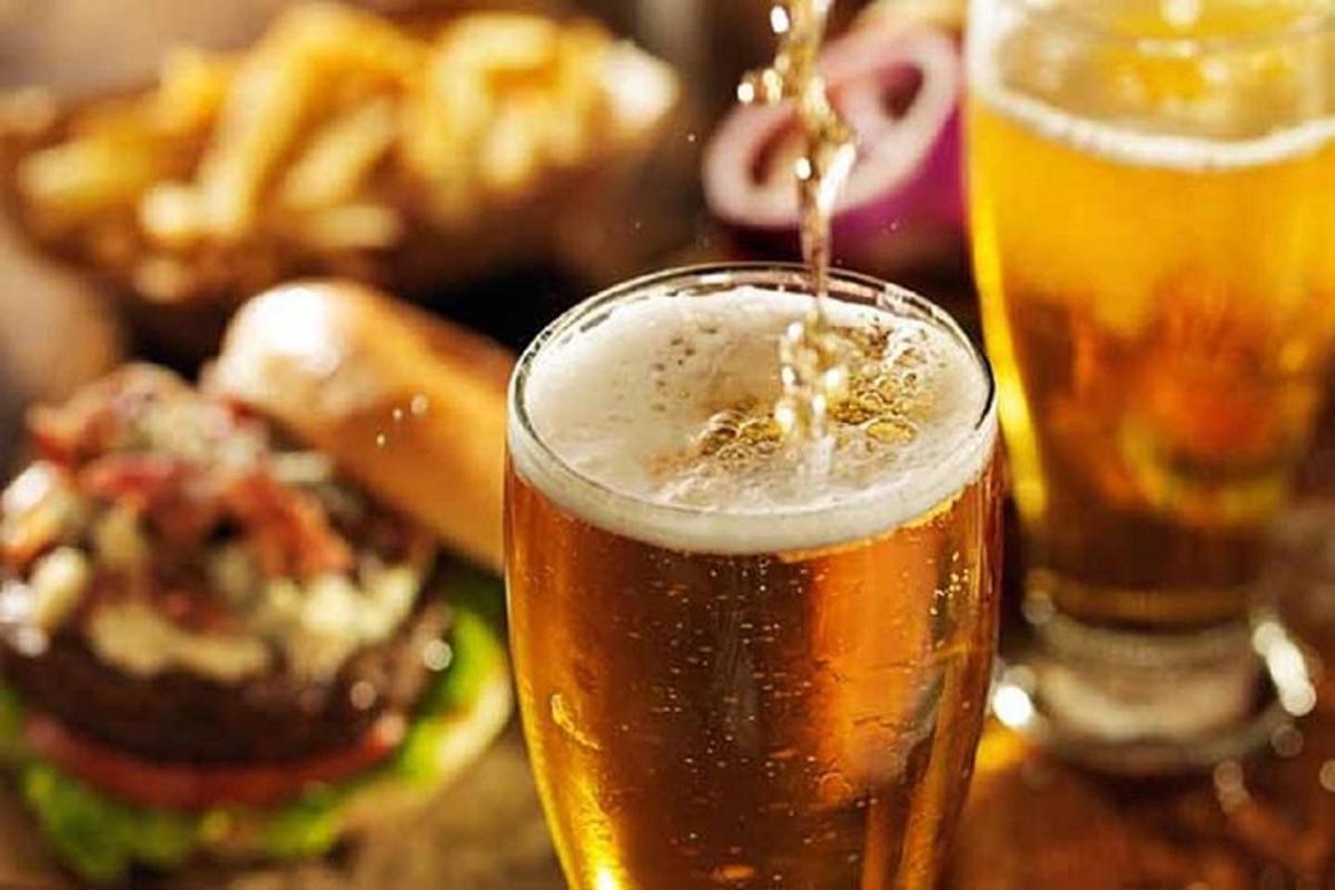 due bicchieri di birra appoggiati su un tavolo con del cibo