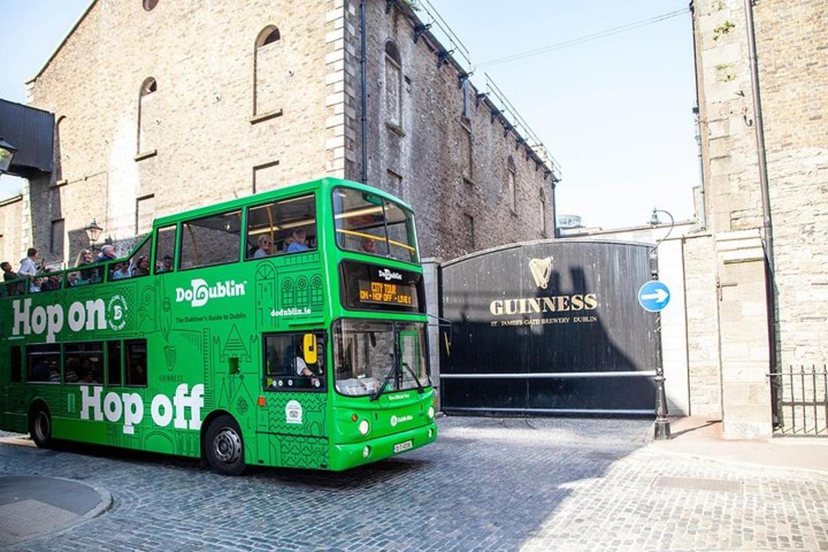 um ônibus verde de dois andares estacionado em frente a um prédio