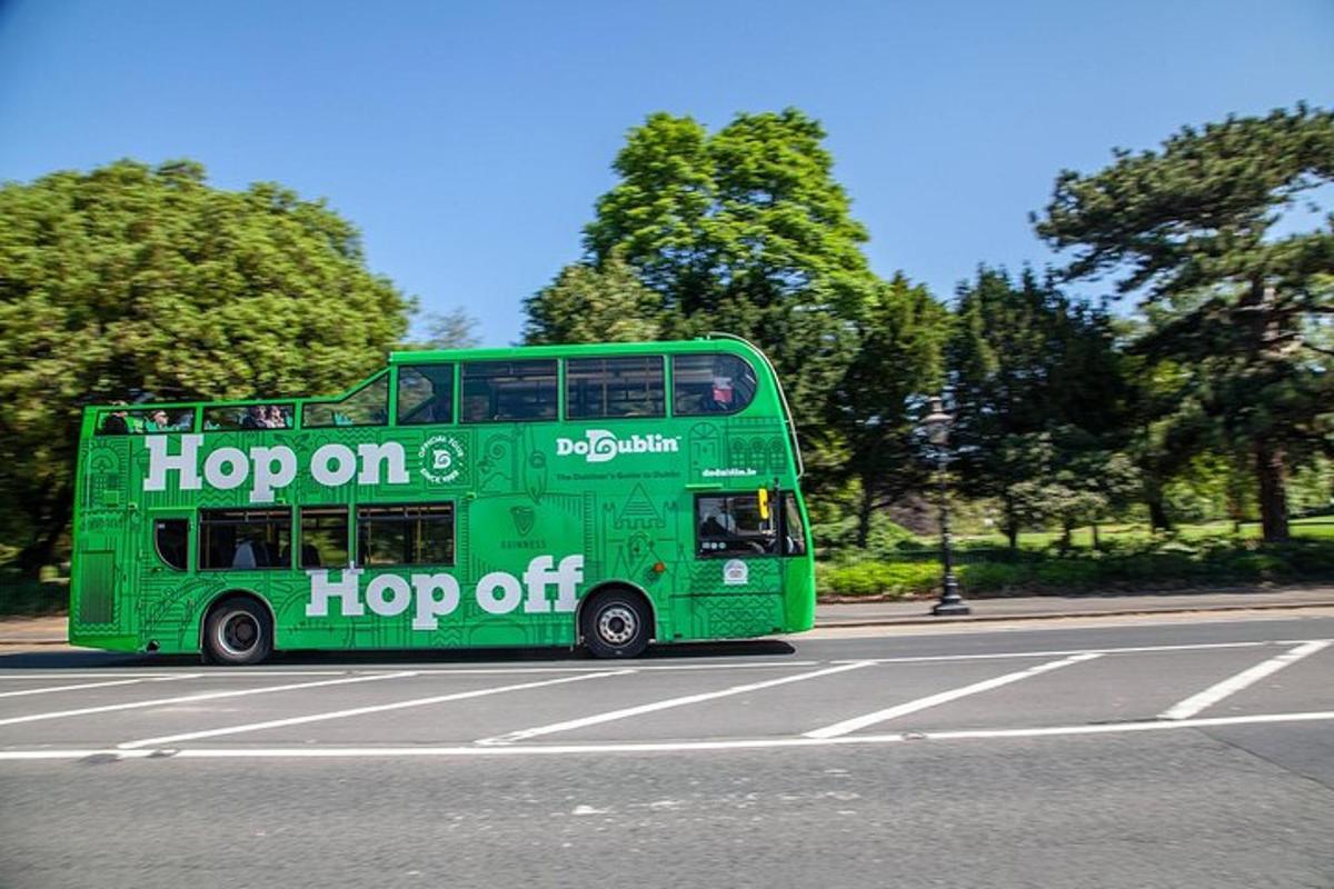 um ônibus verde de dois andares descendo uma rua