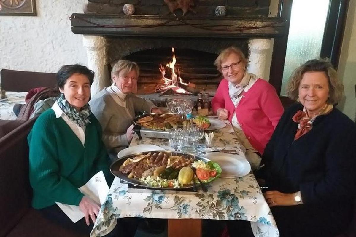 skupina lidí sedících kolem stolu s jídlem