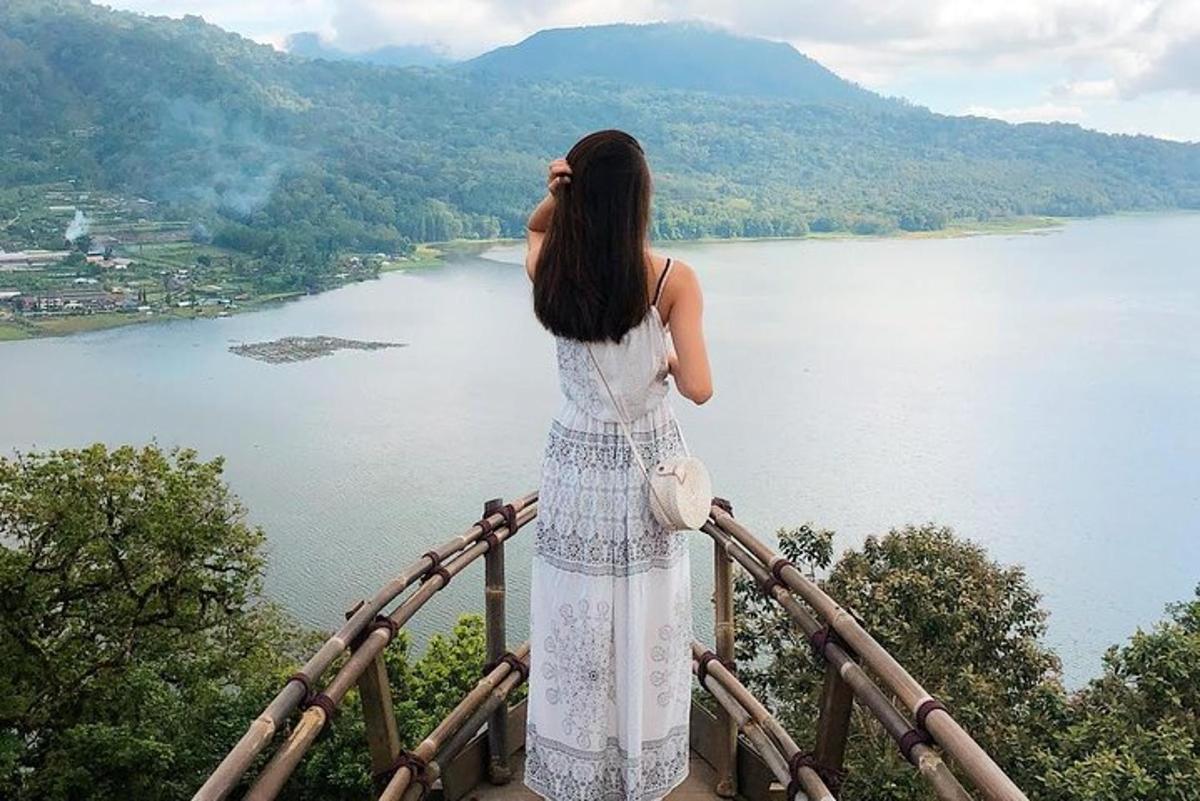a woman in a white dress looking at a lake