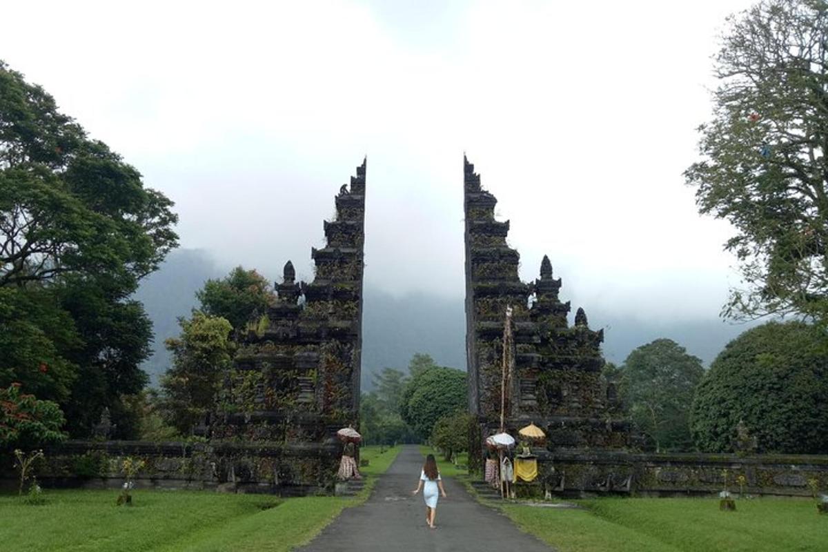 a woman walking down a path in front of a temple