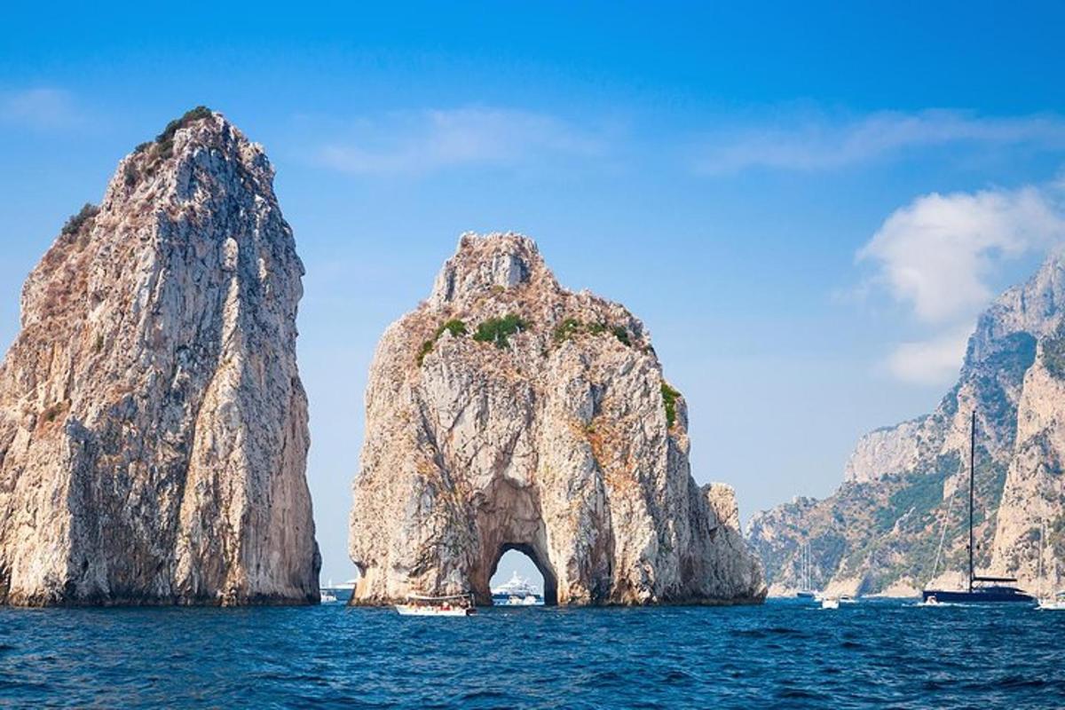 Una gran formación rocosa en el agua con barcos.