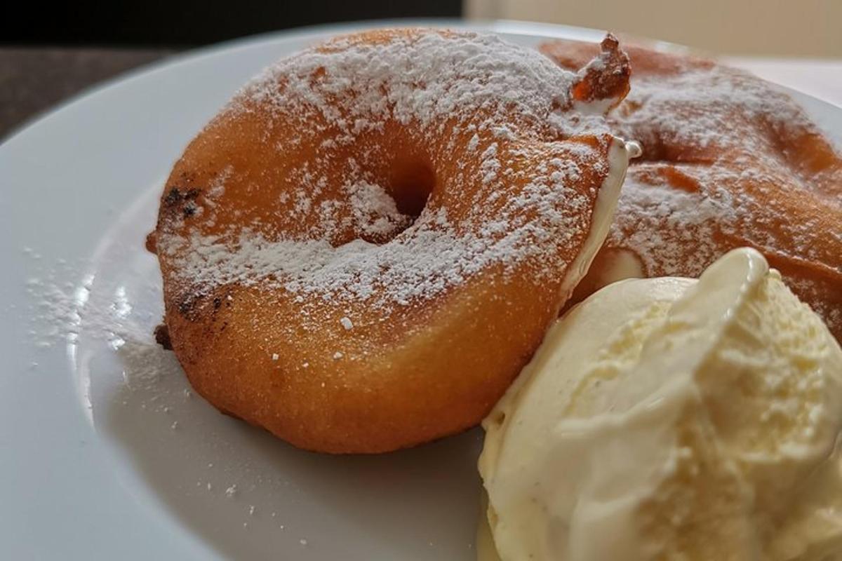 bel krožnik z dvema krofoma in sladoledom