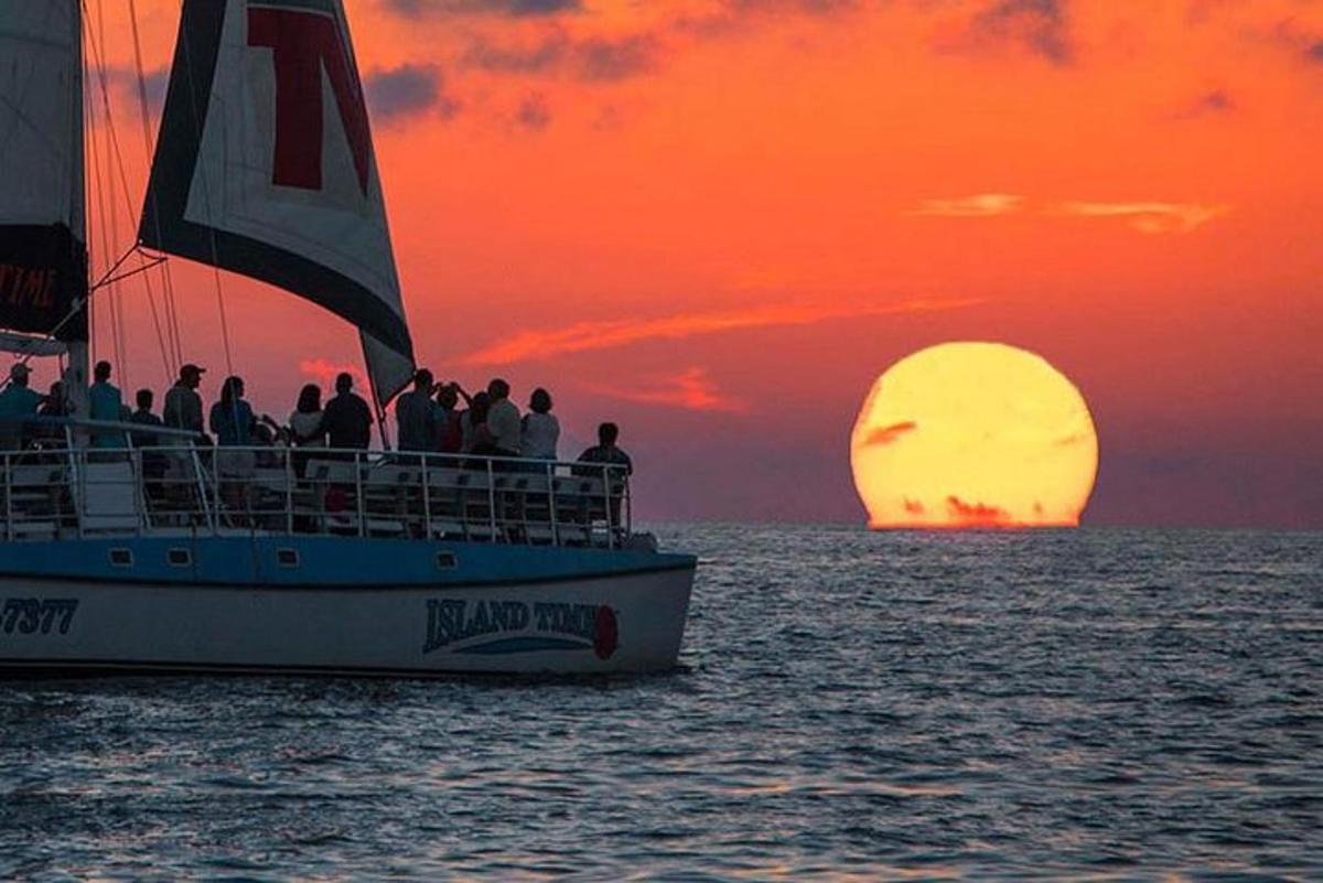 un gruppo di persone su una barca al tramonto