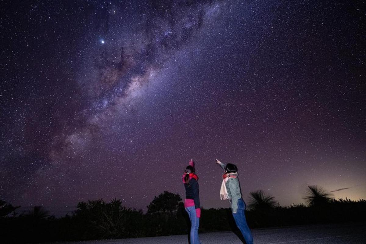 a couple of people looking up at the universe