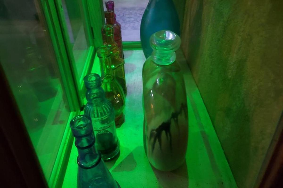 Un grupo de botellas de vidrio colocadas en un estante.