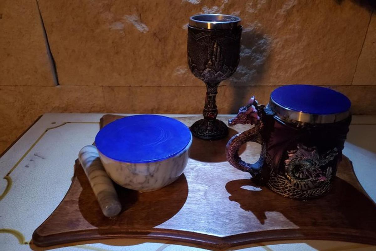Una mesa con dos tazas azules y un mortero.