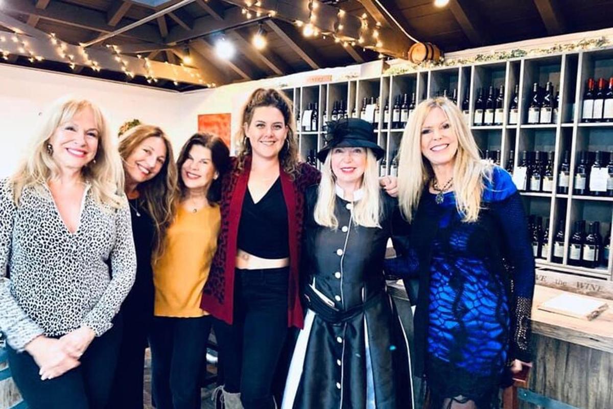 a group of women standing in front of a bar