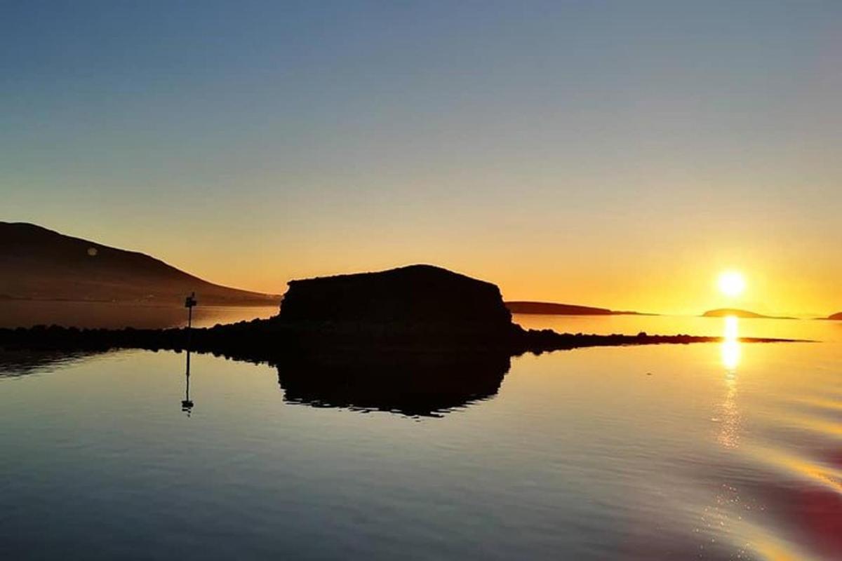 a sunset over a body of water with the sun setting