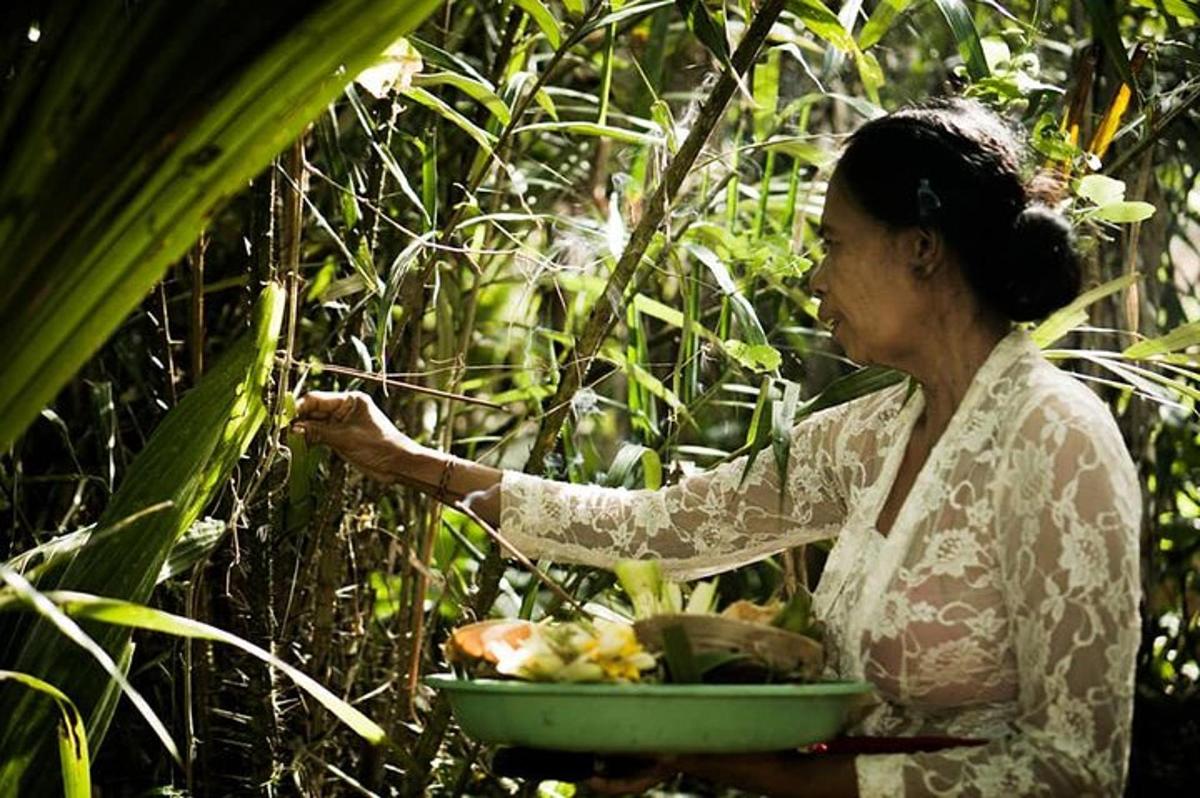 Una mujer sostiene un tazón de fruta.