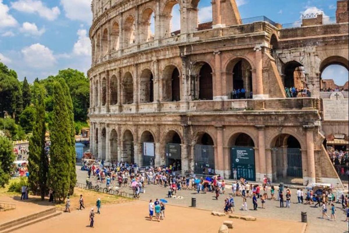 a group of people standing in front of the coliseum
