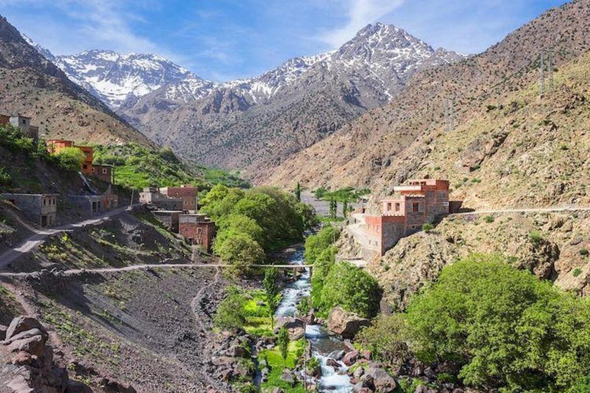 Una vista de un valle de montaña con un río y edificios.